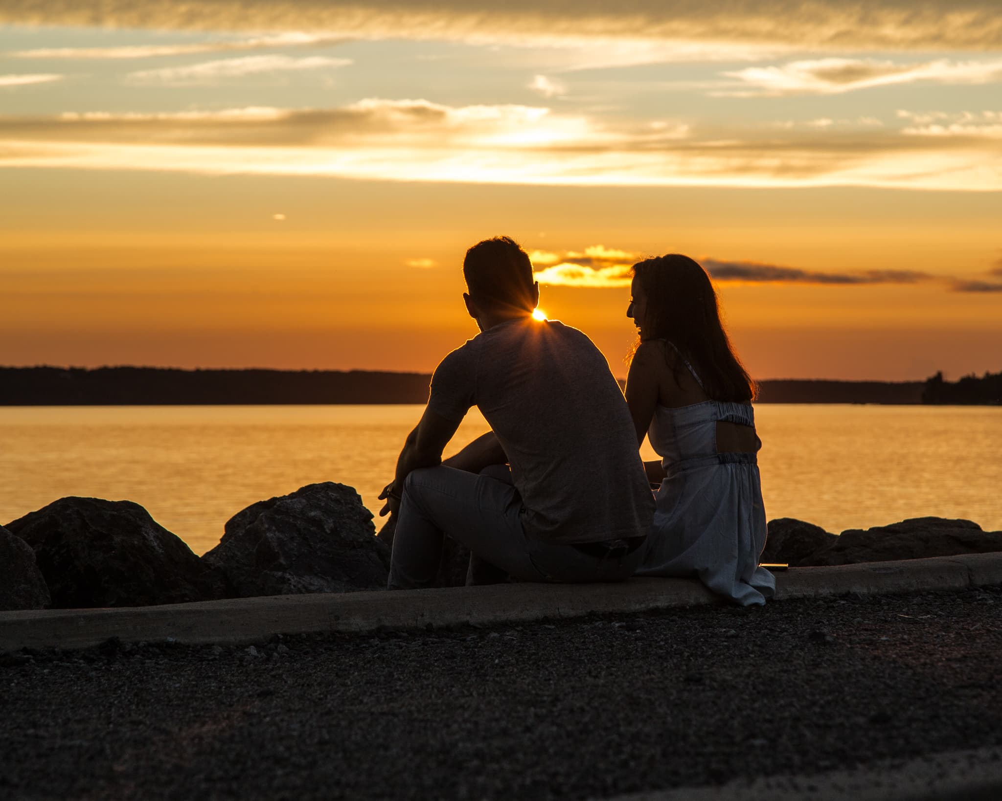 Un couple regardant le coucher de soleil sur la rivière des Outaouais